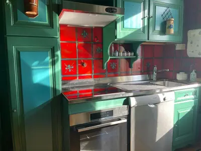 a kitchen with green cabinets and red tiles at Casa in Centro di Cortina D'Ampezzo in Cortina dʼAmpezzo