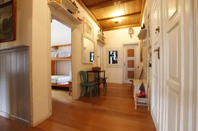 a hallway with a room with a table and a bed at Casa in Centro di Cortina D'Ampezzo in Cortina dʼAmpezzo