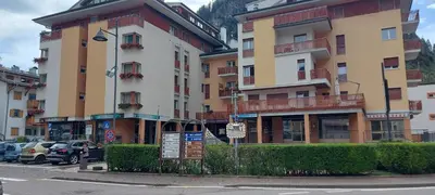 a large building with cars parked in front of it at Casa 33 in Predazzo