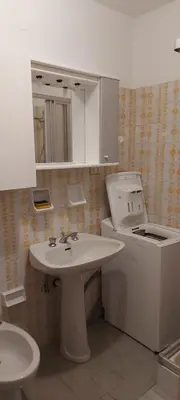a white bathroom with a sink and a toilet at Casa 33 in Predazzo