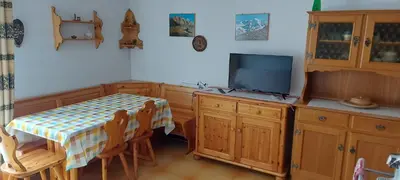 a kitchen with a table and a tv and a table and chairs at Casa 33 in Predazzo