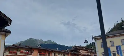 a town with buildings and a mountain in the background at Casa 33 in Predazzo
