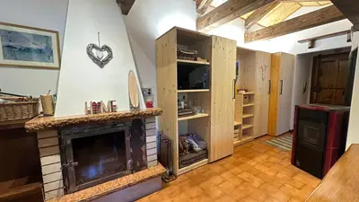 a living room with a fireplace with a heart on the wall at Mansarda Chiara - locazione turistica in Gosaldo