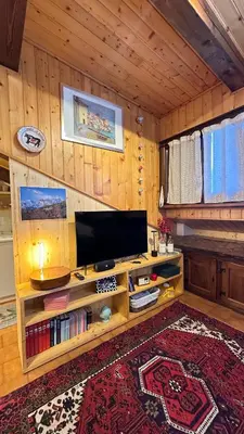 a living room with a tv on a wooden wall at Mansarda Chiara - locazione turistica in Gosaldo