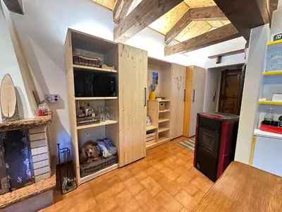 a kitchen with wooden cabinets with a dog sleeping in them at Mansarda Chiara - locazione turistica in Gosaldo