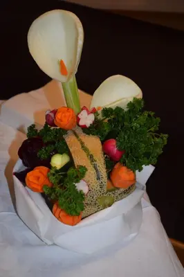 a flower vase filled with vegetables on a table at Hotel Crepes de Sela in Campitello di Fassa