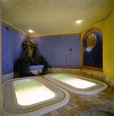 a large bath room with a large tub in a room at Hotel Crepes de Sela in Campitello di Fassa