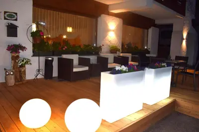 a restaurant with white tables and chairs and flowers at Hotel Crepes de Sela in Campitello di Fassa