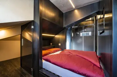 a bunk bed with red sheets in a room at Loft at 1236 in Ortisei