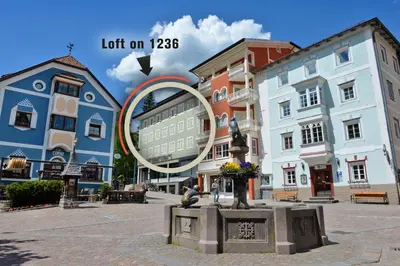 a city with a statue in a square with buildings at Loft at 1236 in Ortisei