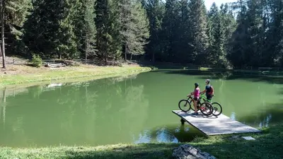 two people riding bikes on a bridge over a lake at Bonichhof in Laion