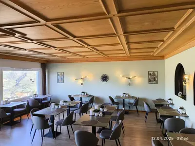 a dining room with tables and chairs and a ceiling at Schenna Garni Eden Bed & Breakfast in Schenna