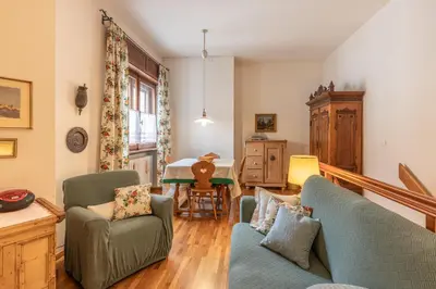 a living room with two chairs and a table at Casa Bigontina, in pieno centro a Cortina in Cortina dʼAmpezzo