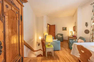a bedroom with a bed and a chair and a lamp at Casa Bigontina, in pieno centro a Cortina in Cortina dʼAmpezzo