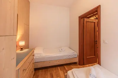 a small bedroom with a bed and an open door at Casa Bigontina, in pieno centro a Cortina in Cortina dʼAmpezzo