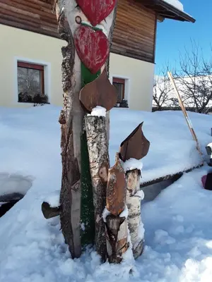 a statue of a tree in the snow at Pension Ferienwohnungen Marchnerhof in Terento