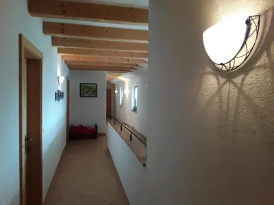 a hallway in a house with a light on the wall at Pension Ferienwohnungen Marchnerhof in Terento