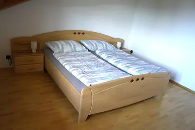 a bed in a bedroom with a wooden headboard at Schabelhof in Laives