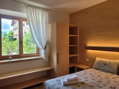 a bedroom with a bed and a window at Posta Apartments in Colle Santa Lucia