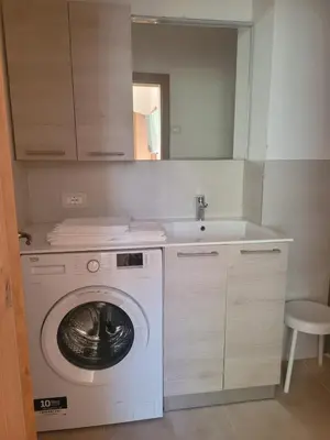a kitchen with a washing machine and a sink at Posta Apartments in Colle Santa Lucia