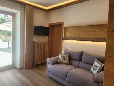 a living room with a couch and a television at Posta Apartments in Colle Santa Lucia