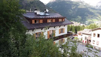 a building with a roof on top of a mountain at Posta Apartments in Colle Santa Lucia