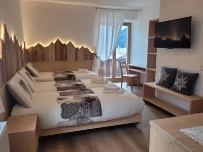 a large bedroom with a large bed and a desk at Posta Apartments in Colle Santa Lucia