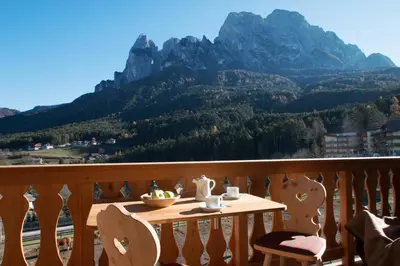a table on a balcony with a view of a mountain at Trafunshof natural living in Vols am Schlern