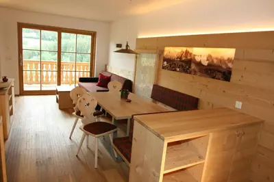 a living room with a table and a couch at Trafunshof natural living in Vols am Schlern