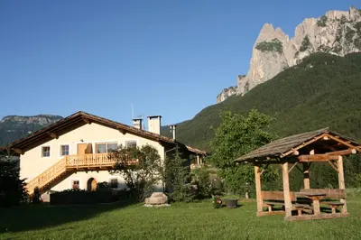 a house in front of a mountain at Trafunshof natural living in Vols am Schlern