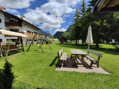 a picnic table and an umbrella and a playground at Residence Luisa in Pera