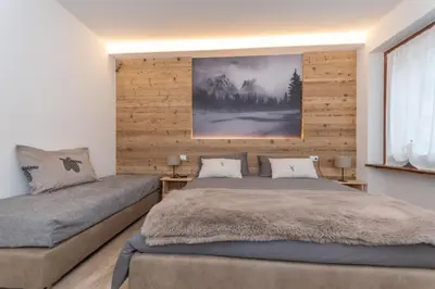 a bedroom with a bed and a couch at Ciesa Abete Rosso in Caprile