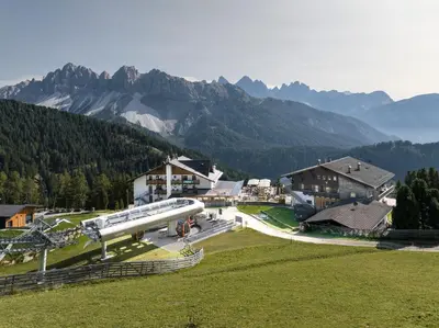 an airplane is parked on a field in front of mountains at Berghotel Schlemmer Appartements in Plancios