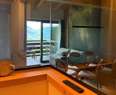 a living room with a glass table and a couch at Olimpo Dolomitico in Cavalese