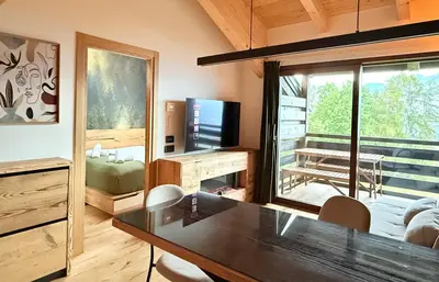 a living room with a dining table and a television at Olimpo Dolomitico in Cavalese