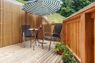 a patio with a table and chairs and an umbrella at Berggasthof Locanda Alpina Dorfner in Montagna