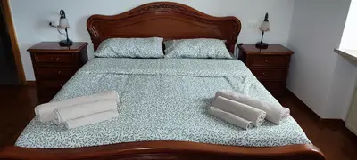 a bedroom with a bed with two pillows and two night stands at Casa Ianes in Ronzone