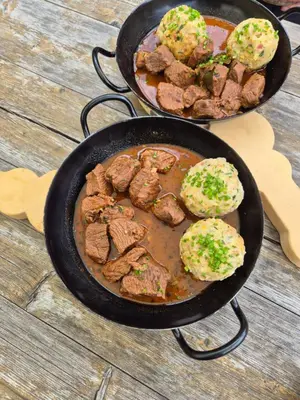 two pans filled with meat and biscuits on a table at Apartment Dreiland in Plaus