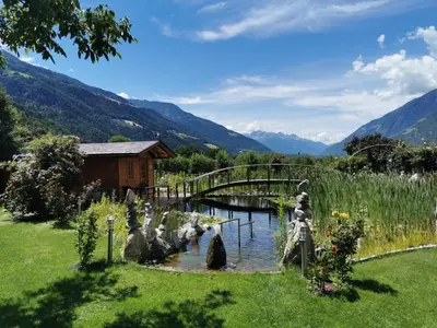 a bridge over a river in a field with mountains at Apartment Dreiland in Plaus