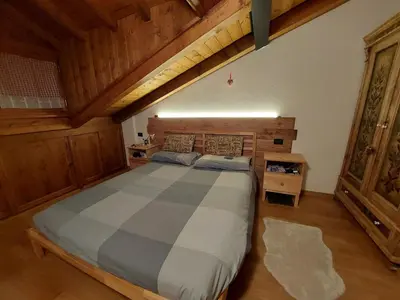 a bedroom with a large bed in a room at Petit Chalet in Villanova