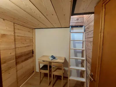 a small room with a table and a ladder at Petit Chalet in Villanova