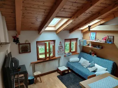 a living room with a blue couch and a tv at Petit Chalet in Villanova
