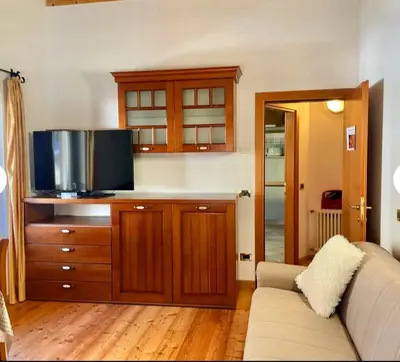 a living room with a couch and a flat screen tv at Cèsa Niki in Canazei