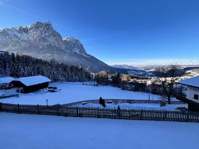 a snow covered yard with a fence and a mountain at AppartmentPircher 2 in Siusi