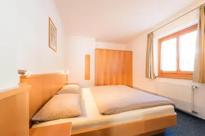 a bedroom with a bed and a window at AppartmentPircher 2 in Siusi