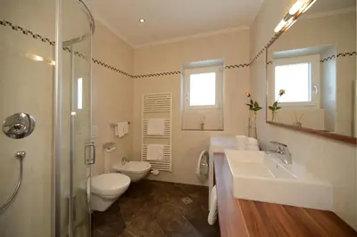 a bathroom with a sink and a toilet and a shower at Apartments Villa Montana in Ortisei