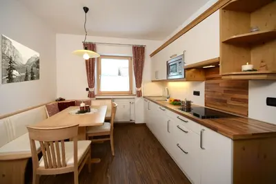 a kitchen with a table and a dining room at Apartments Villa Montana in Ortisei