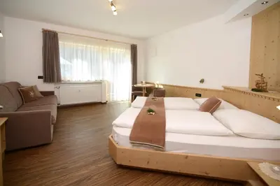 a living room with a bed and a couch at Apartments Villa Montana in Ortisei