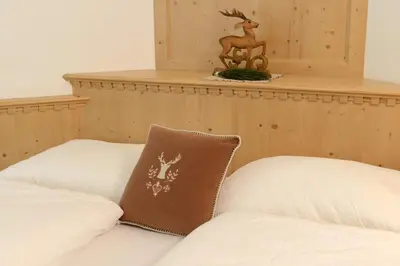 a white couch with a brown pillow on it at Apartments Villa Montana in Ortisei