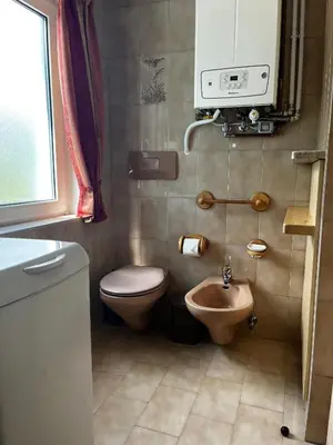 a small bathroom with a toilet and a sink at Appartamento Le Sipole in Ziano di Fiemme